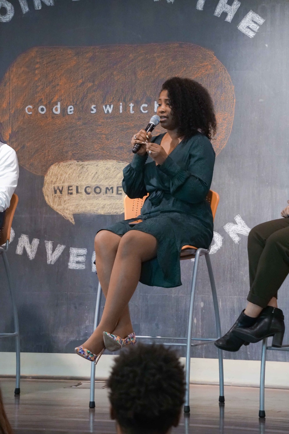 Michelle Edwards speaking on a panel with a microphone.